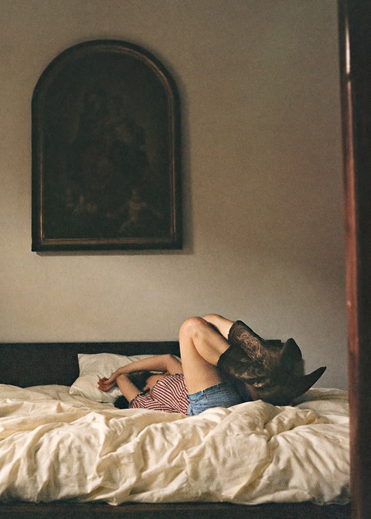 A woman laying on the bed with her legs in the air