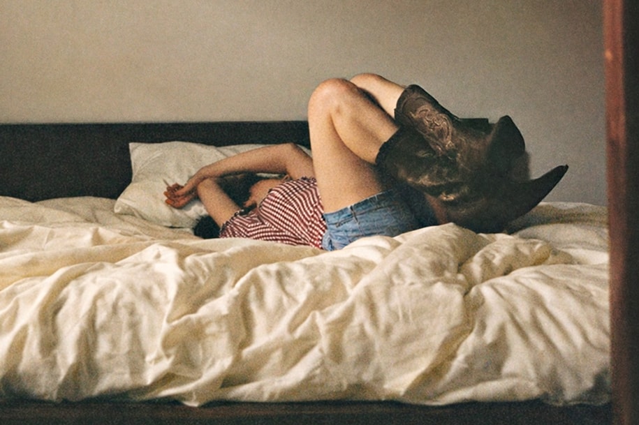 A woman laying on the bed with her legs in the air